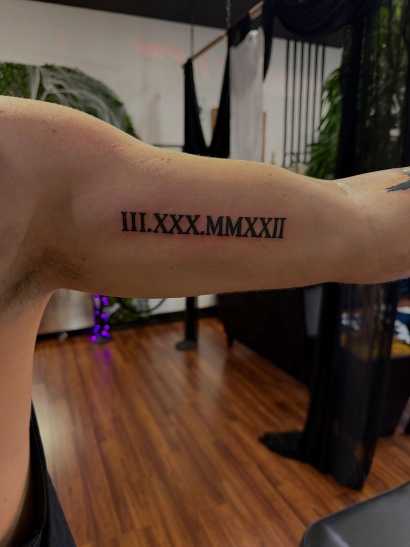Roman numeral date in fine script on an upper arm